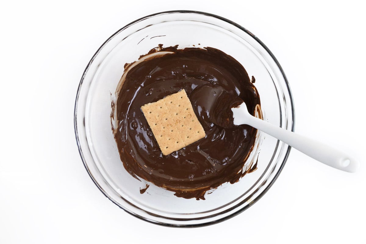 A graham cracker square dipped in melted chocolate.