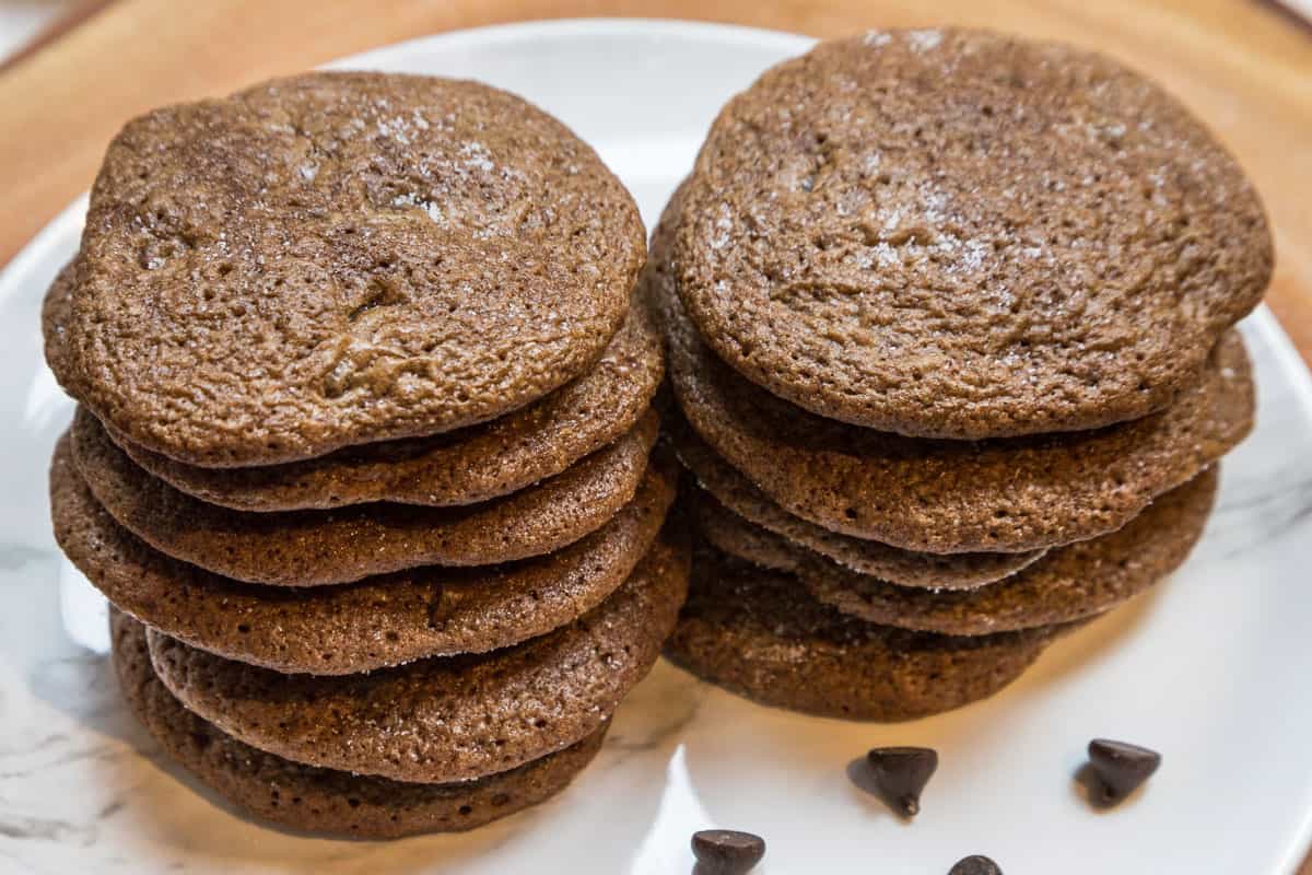 A stack of sea salt chocolate chip cookies on a plate.