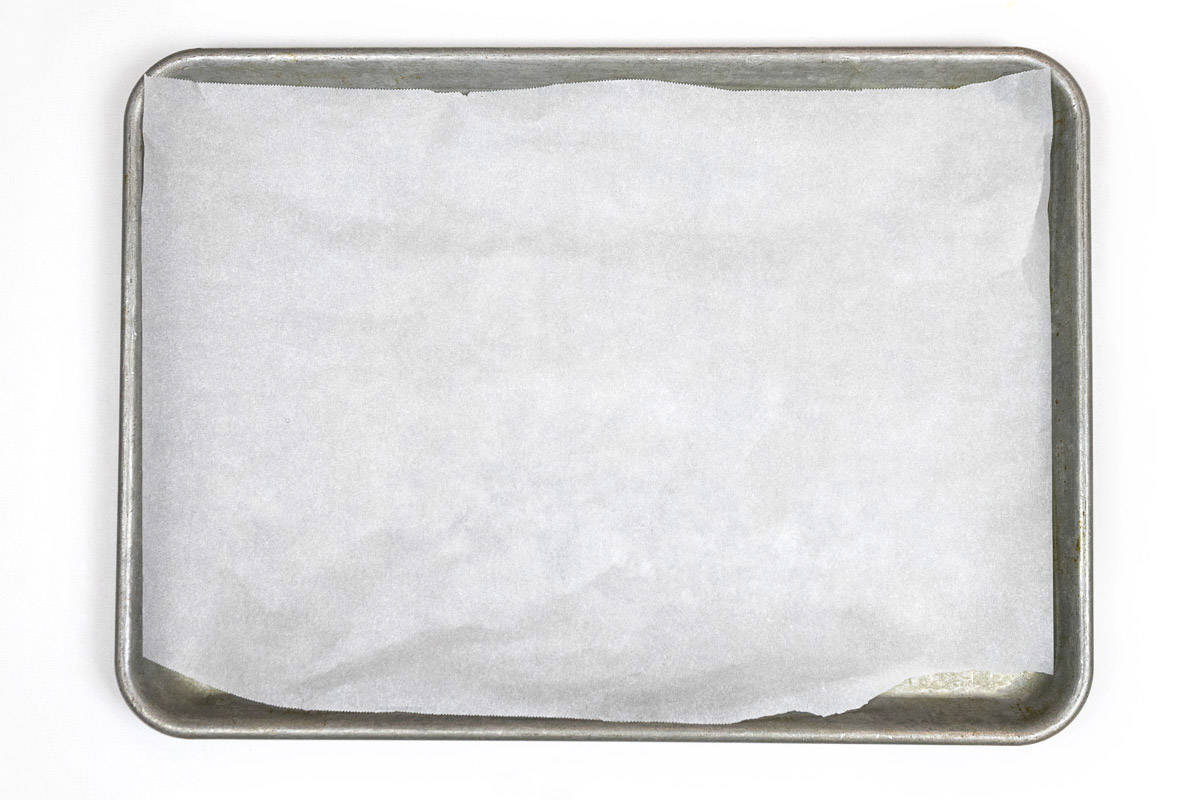 A cookie sheet lined with parchment paper.