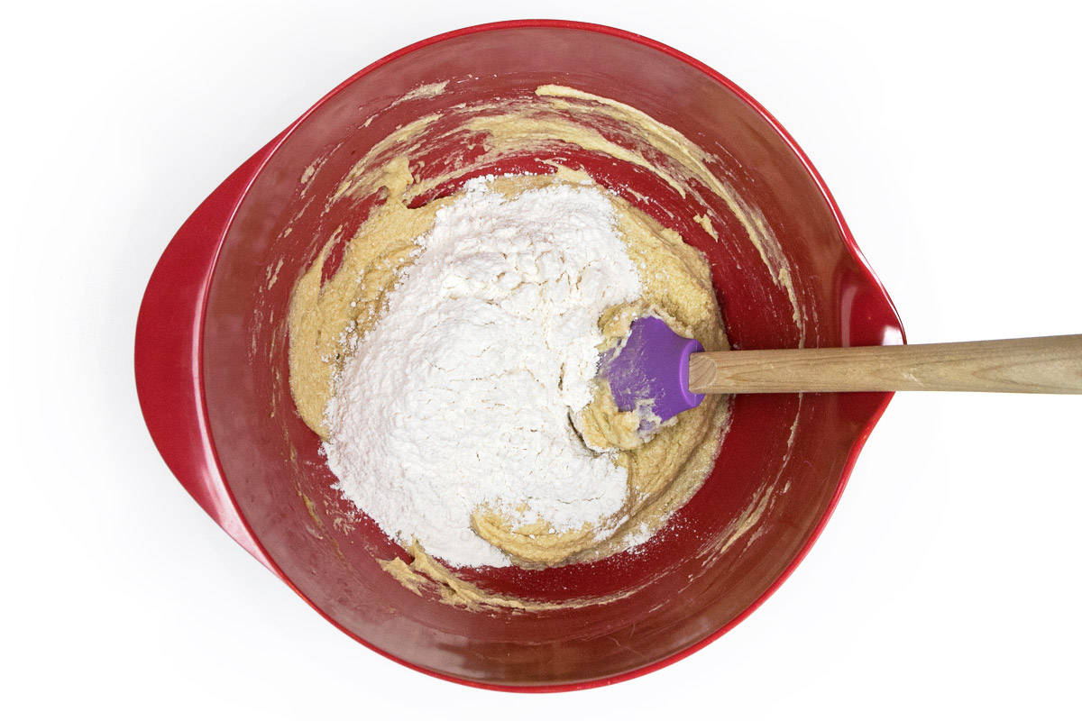 The flour mixture is added to the vanilla extract, eggs, softened butter, granulated sugar, and light brown sugar.