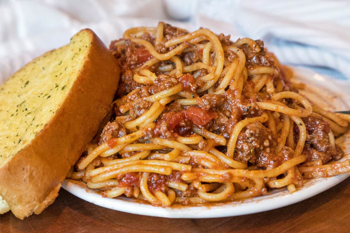 Instant Pot spaghetti with meat and garlic bread on a plate.
