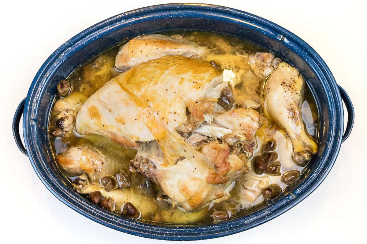 Oven baked turkey and legs in a roasting pan.