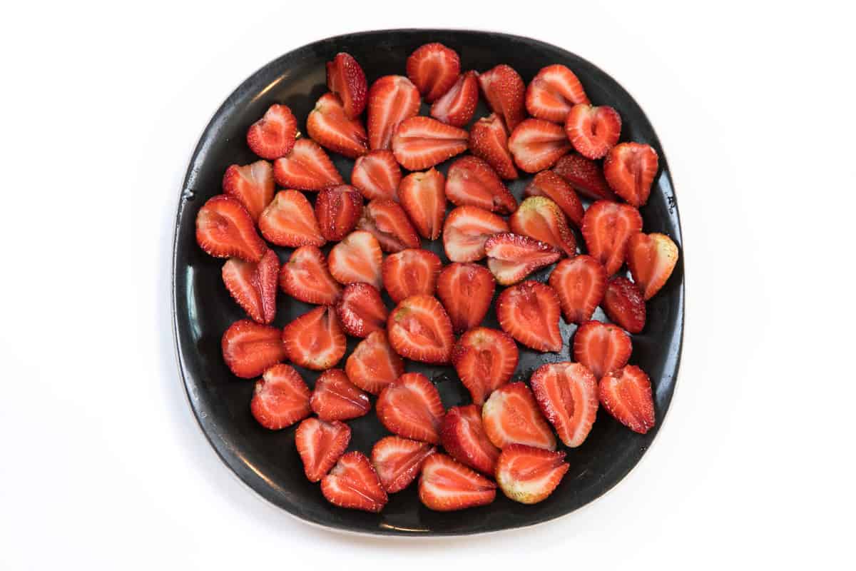 Strawberries cut in half on a plate.