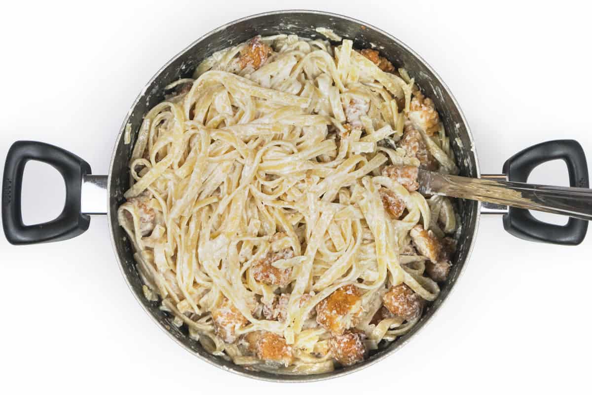 Crispy chicken fettuccine Alfredo in a large pot.