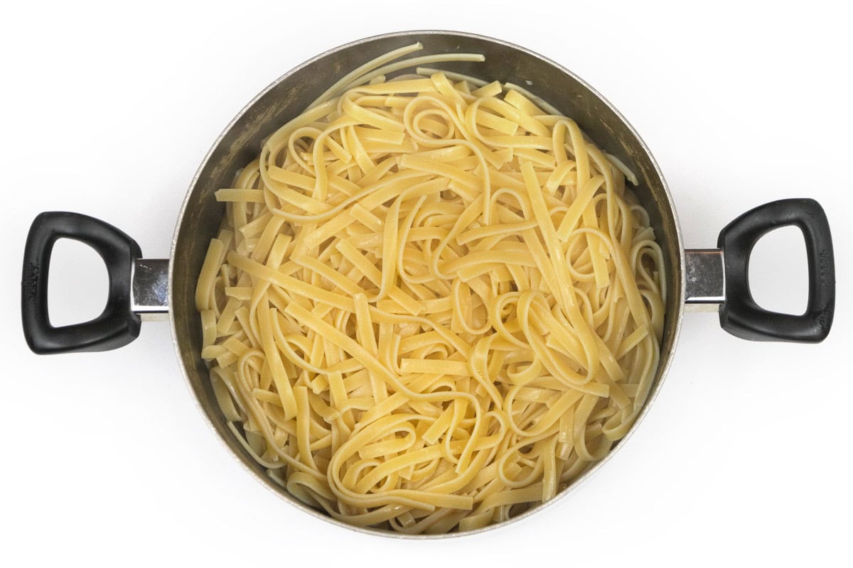 Cooked fettuccine noodles in a large pot.