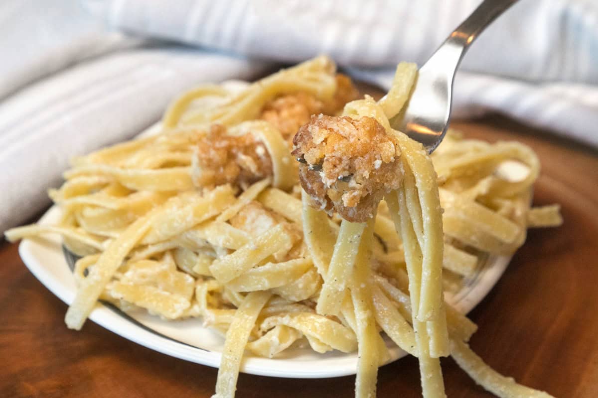 Crispy chicken fettuccine Alfredo on a plate.