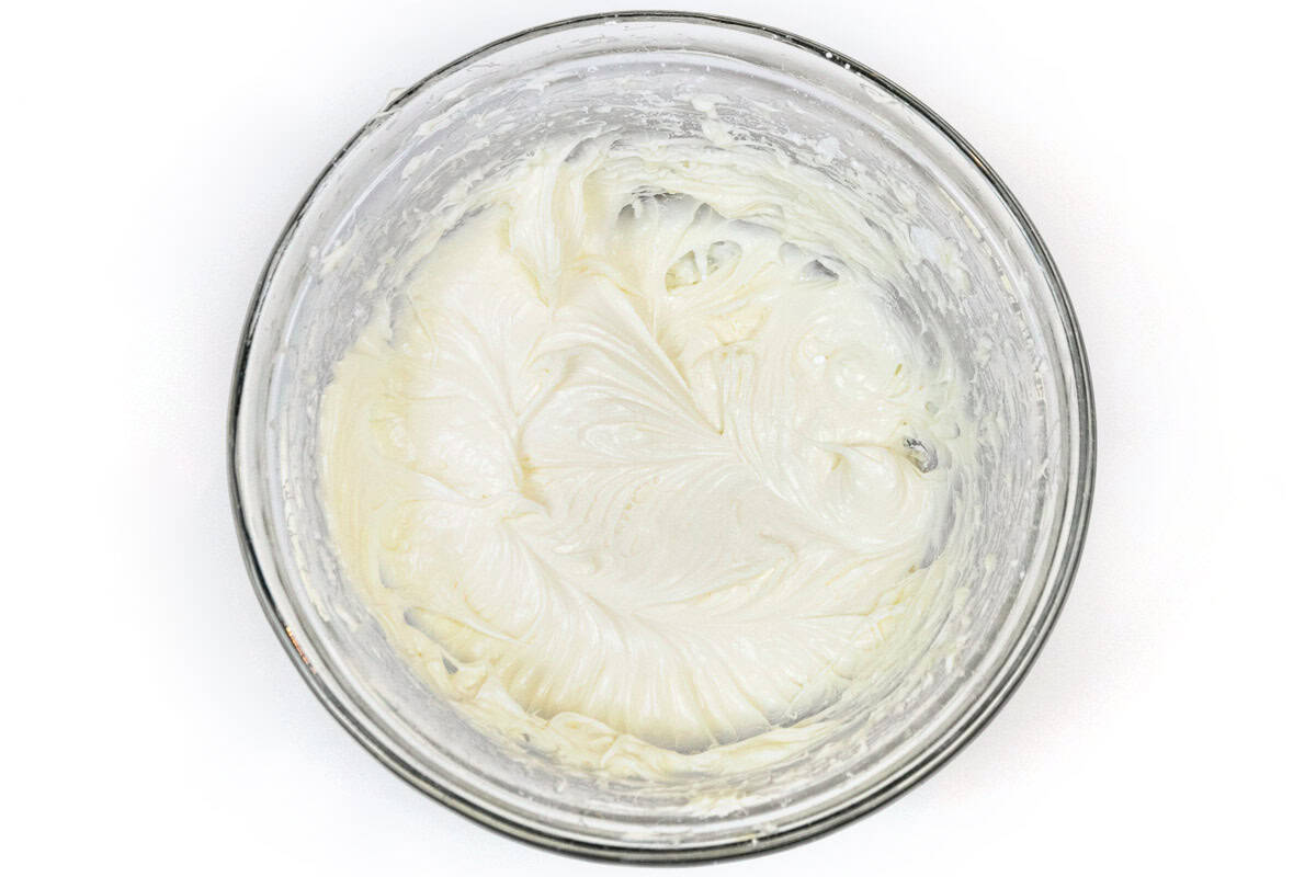 The softened cream cheese, powdered sugar, and vanilla extract are mixed together in a bowl.