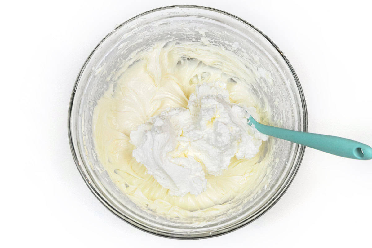 The whipped cream mixture is added to the cream cheese mixture.