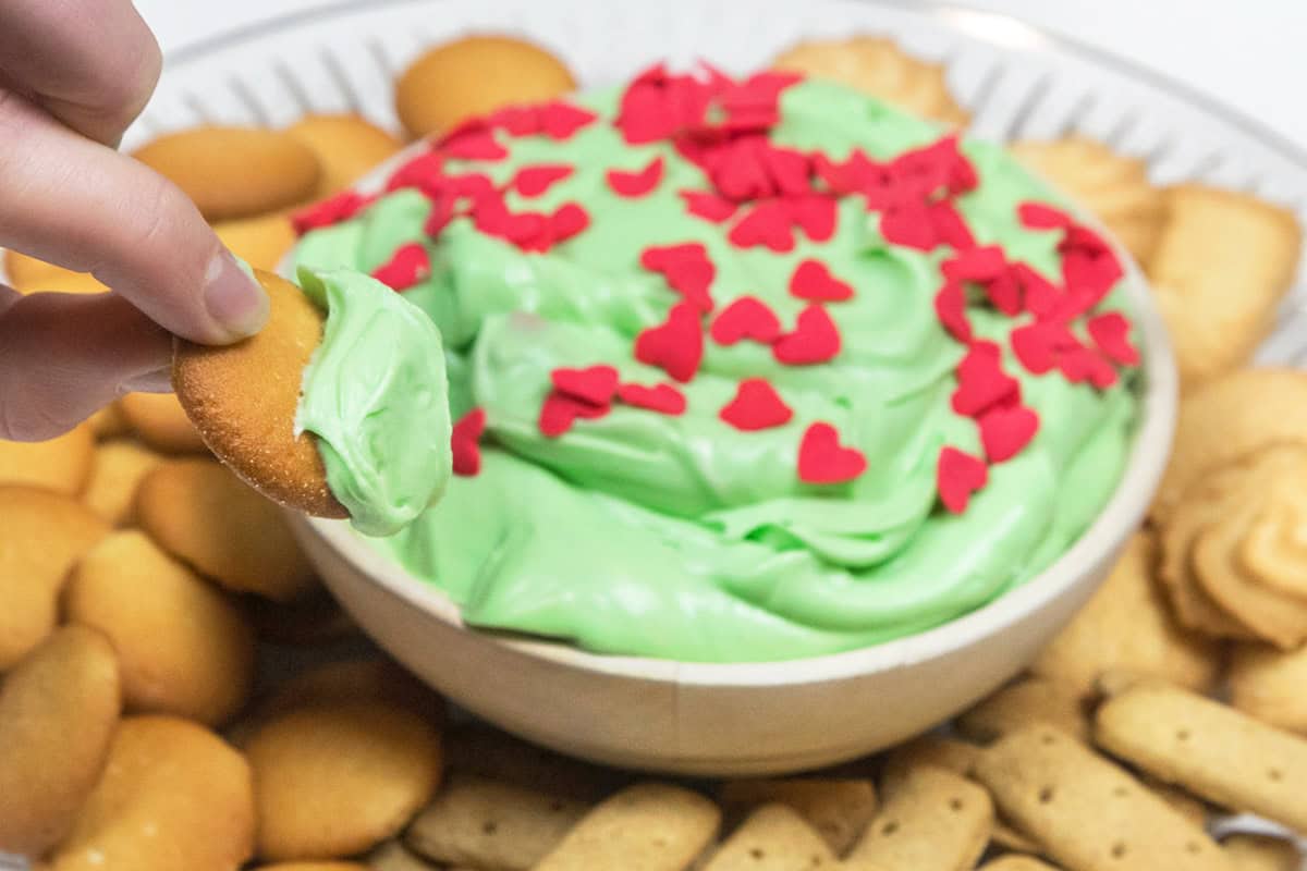 A cookie dipped in the Grinch dip recipe (Christmas Dessert).