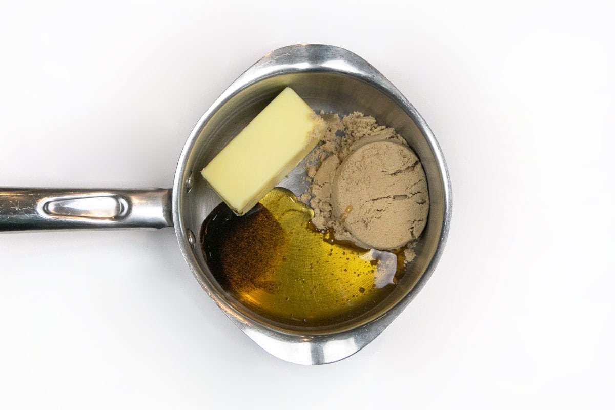 Unsalted butter, brown sugar, honey, and vanilla bean paste in a saucepan.