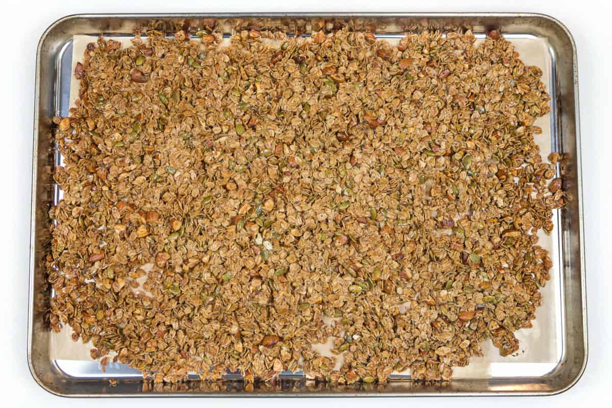 Almond granola with honey on a cookie sheet after baking in the oven.