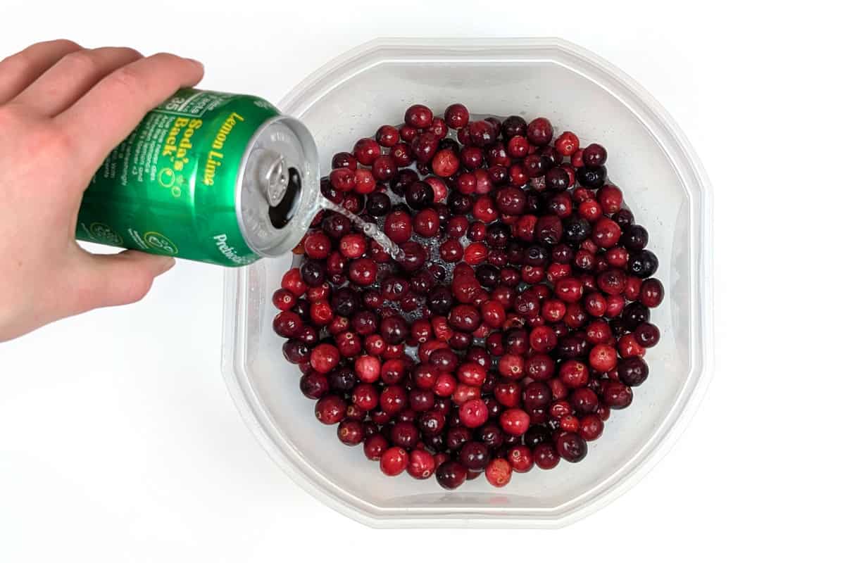Soda pop added to the bowl with the fresh cranberries.