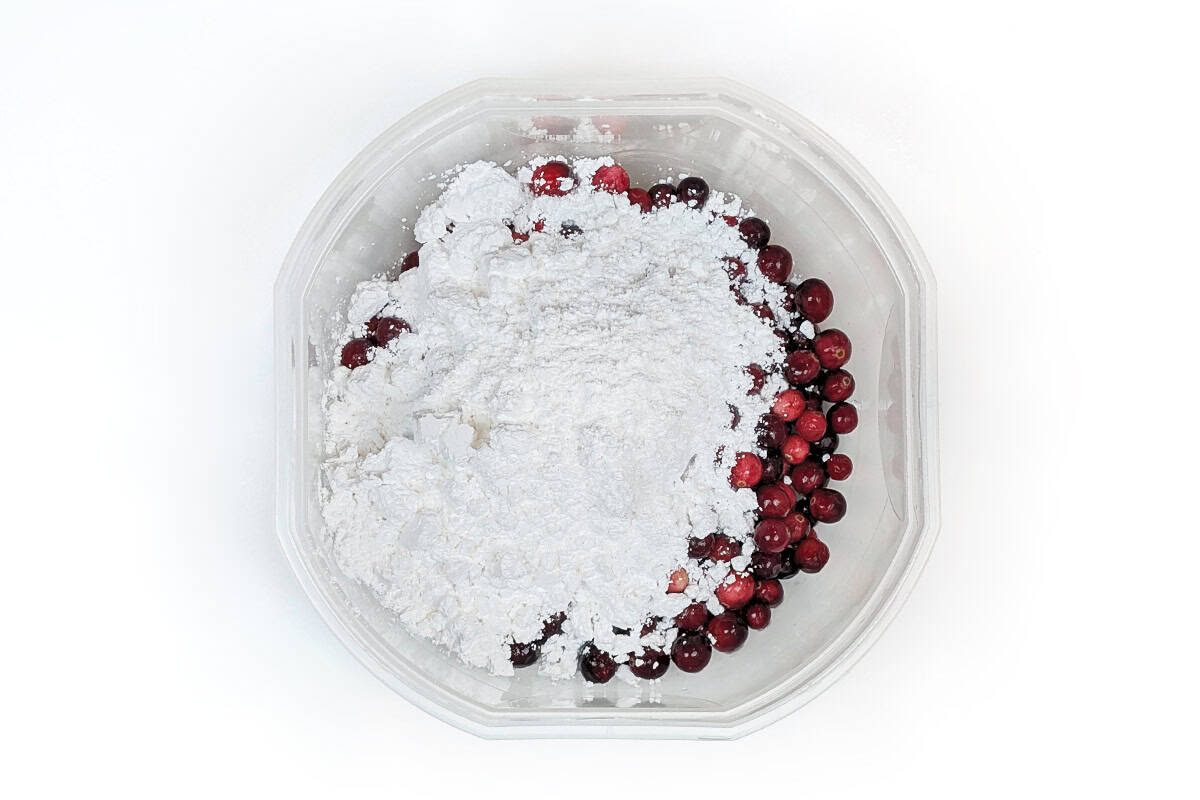 Powdered sugar added to cranberries.