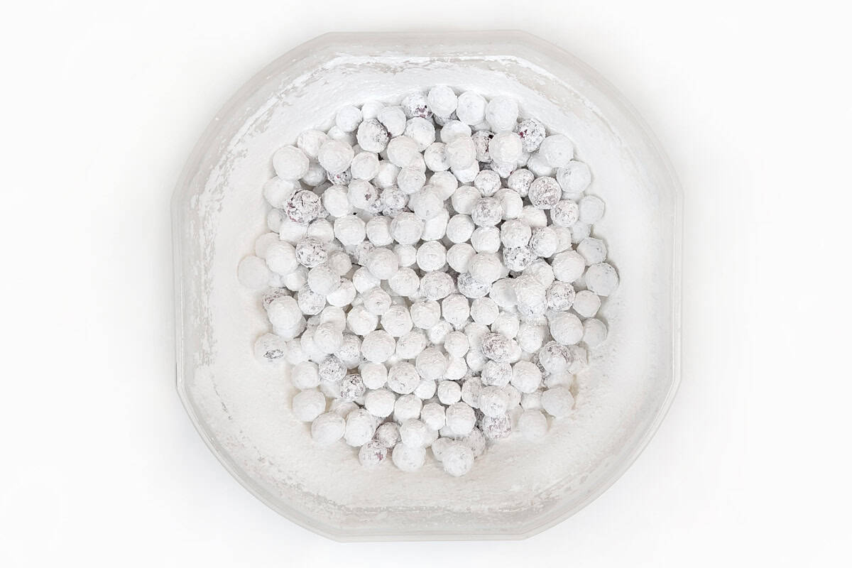 A bowl of cranberries coated with powdered sugar.