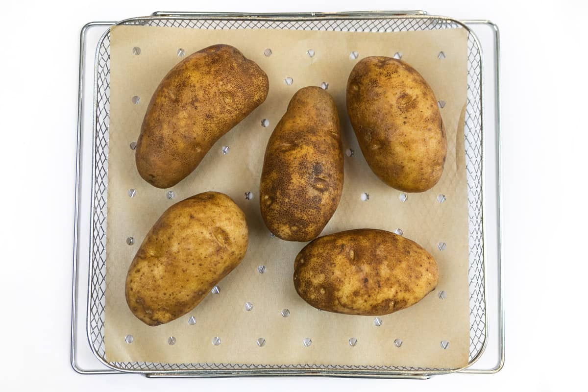 Place potatoes on parchment paper in the air fryer basket.