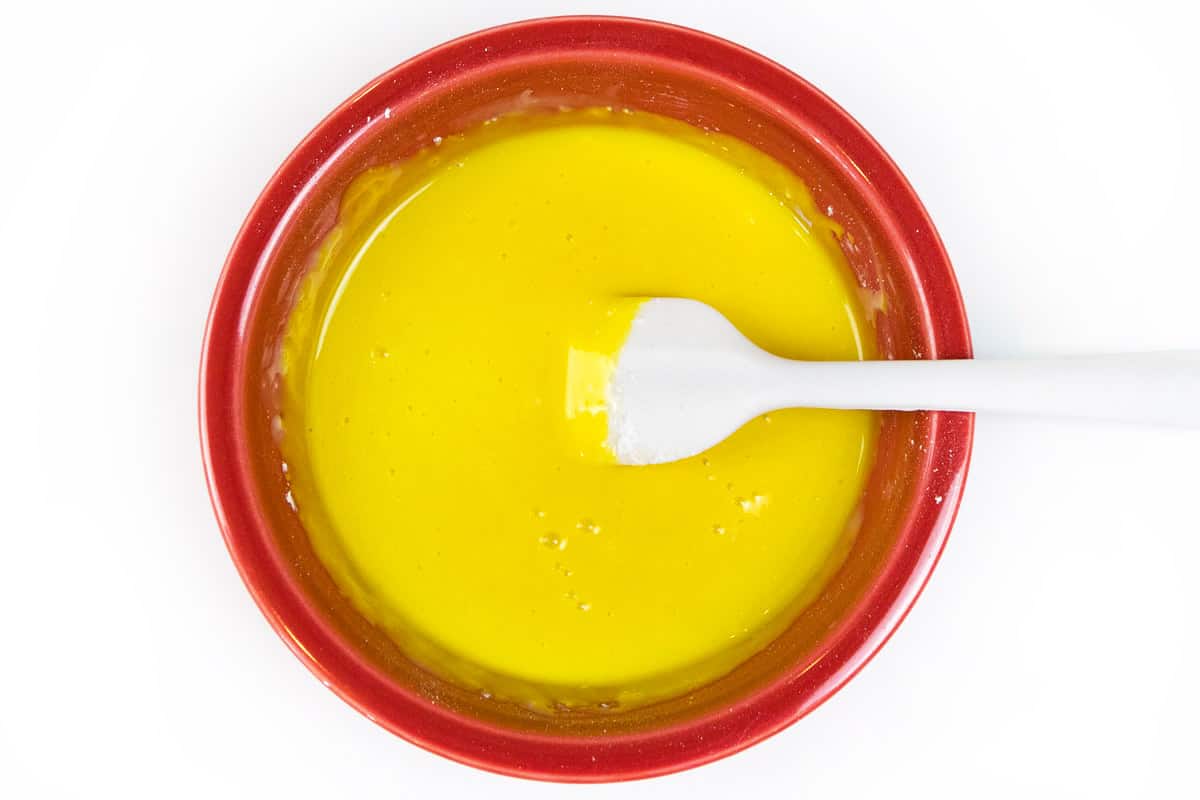 Yellow food coloring is added together with the powdered sugar, milk, and vanilla extract.