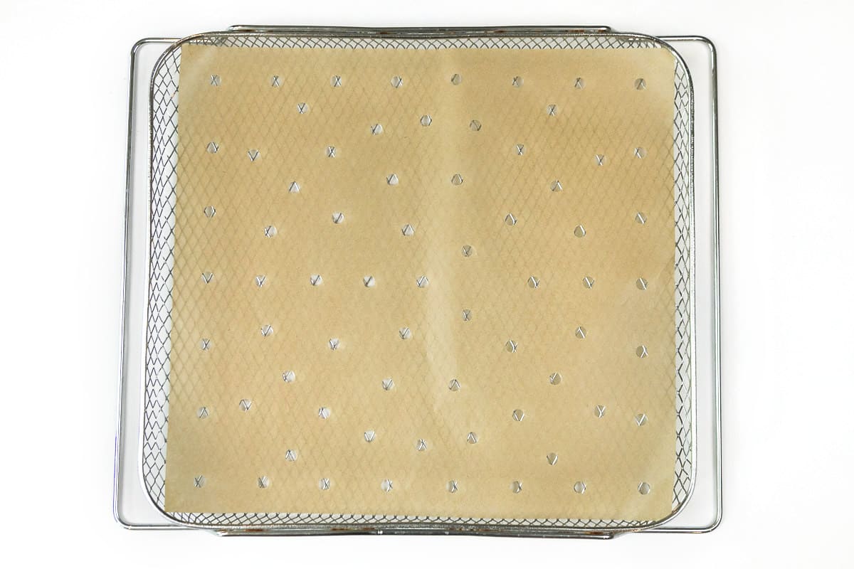 Pre-cut parchment paper with holes on the air fryer basket.