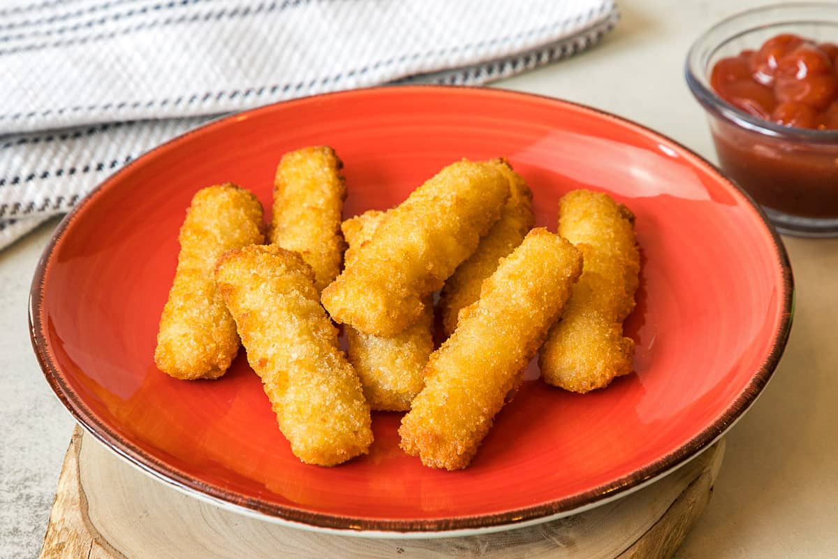 Crispy air fryer fish sticks on a plate.