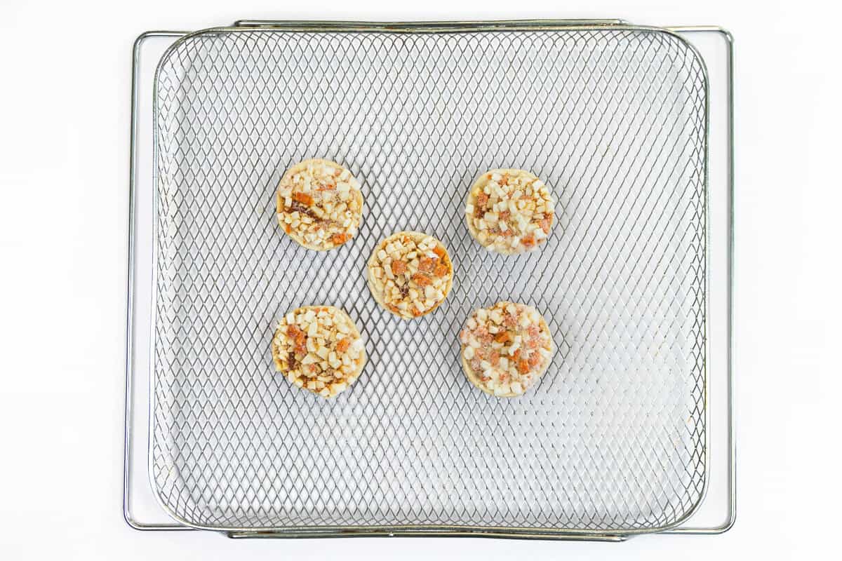 Place the mini pizza bagels on the air fryer basket.