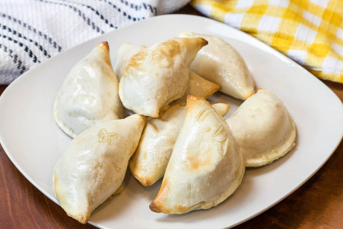 Potato and cheese pierogies on a plate.