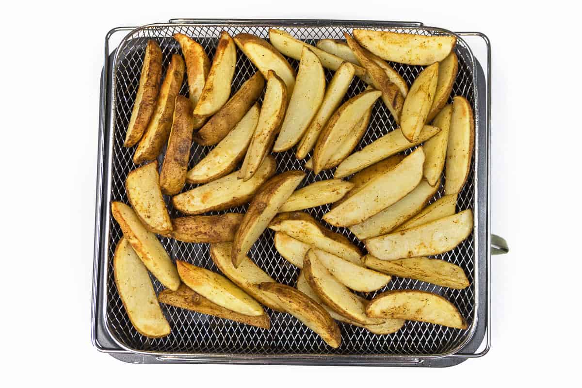 Bake the potato wedges in the air fryer at four hundred degrees Fahrenheit for twenty-five to thirty minutes.