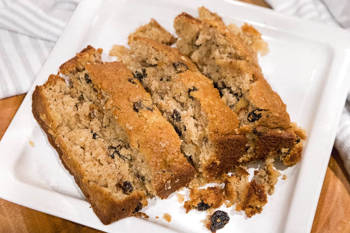 Applesauce cake cut up into slices on a white plate. 