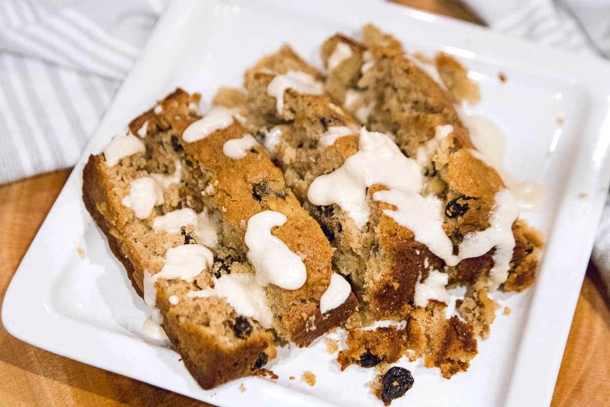 Applesauce spice cake with icing on a plate.