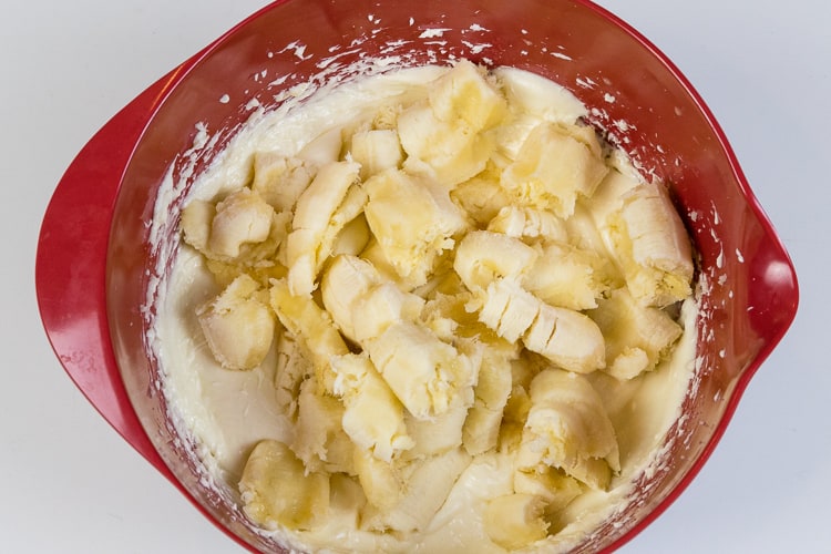 Four bananas are added to the bowl with the cream cheese mixture.