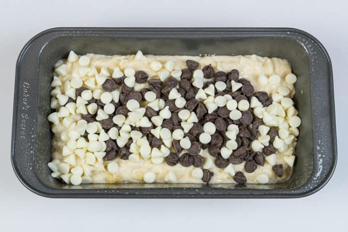 Chocolate chips and white chocolate chips are added to one of the loaf pans with the banana bread batter.
