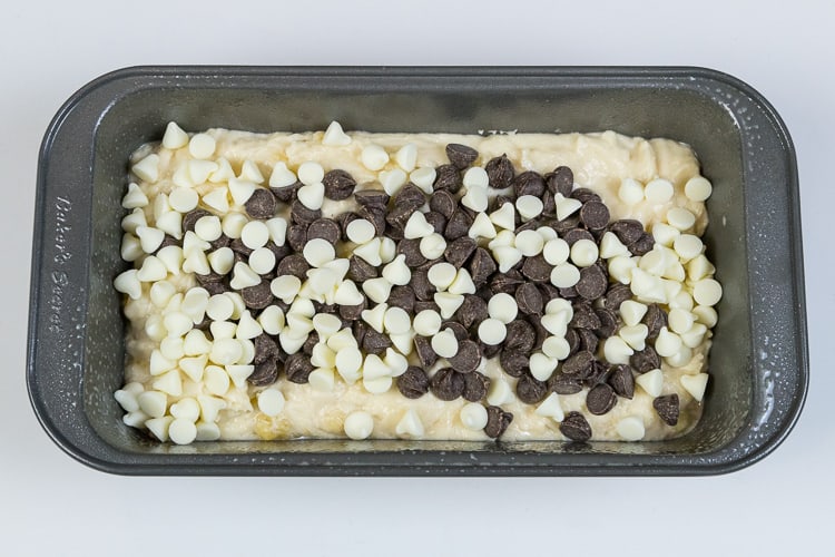 Add chocolate chips and white chocolate chips to the loaf pan with the banana bread batter.
