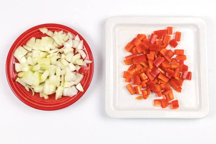 Chop one onion and one red bell pepper for beef enchilada.