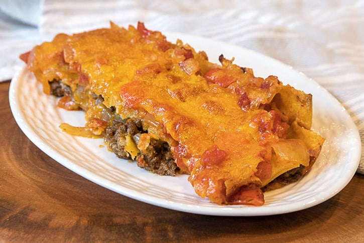 One beef enchilada on a plate.