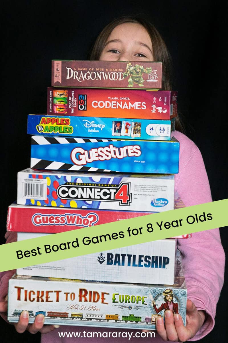 8 year old holding board games.