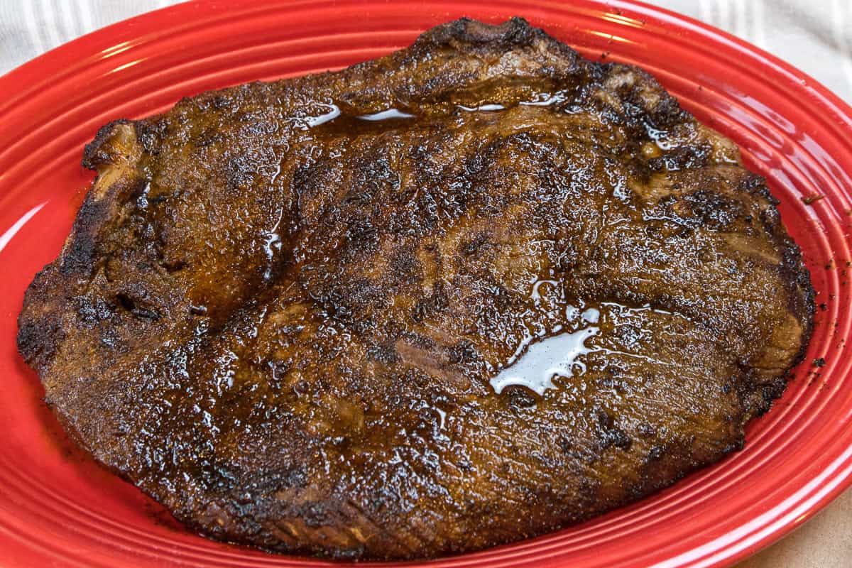 Broiled flank steak on a plate.
