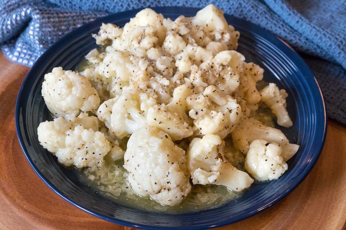A plate of buttered cauliflower with black pepper.