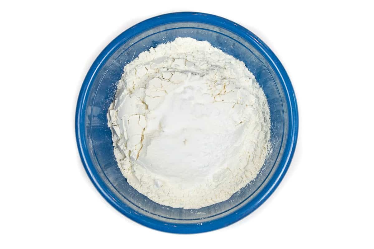 Flour, baking soda, baking powder, and sea salt are added to a bowl.