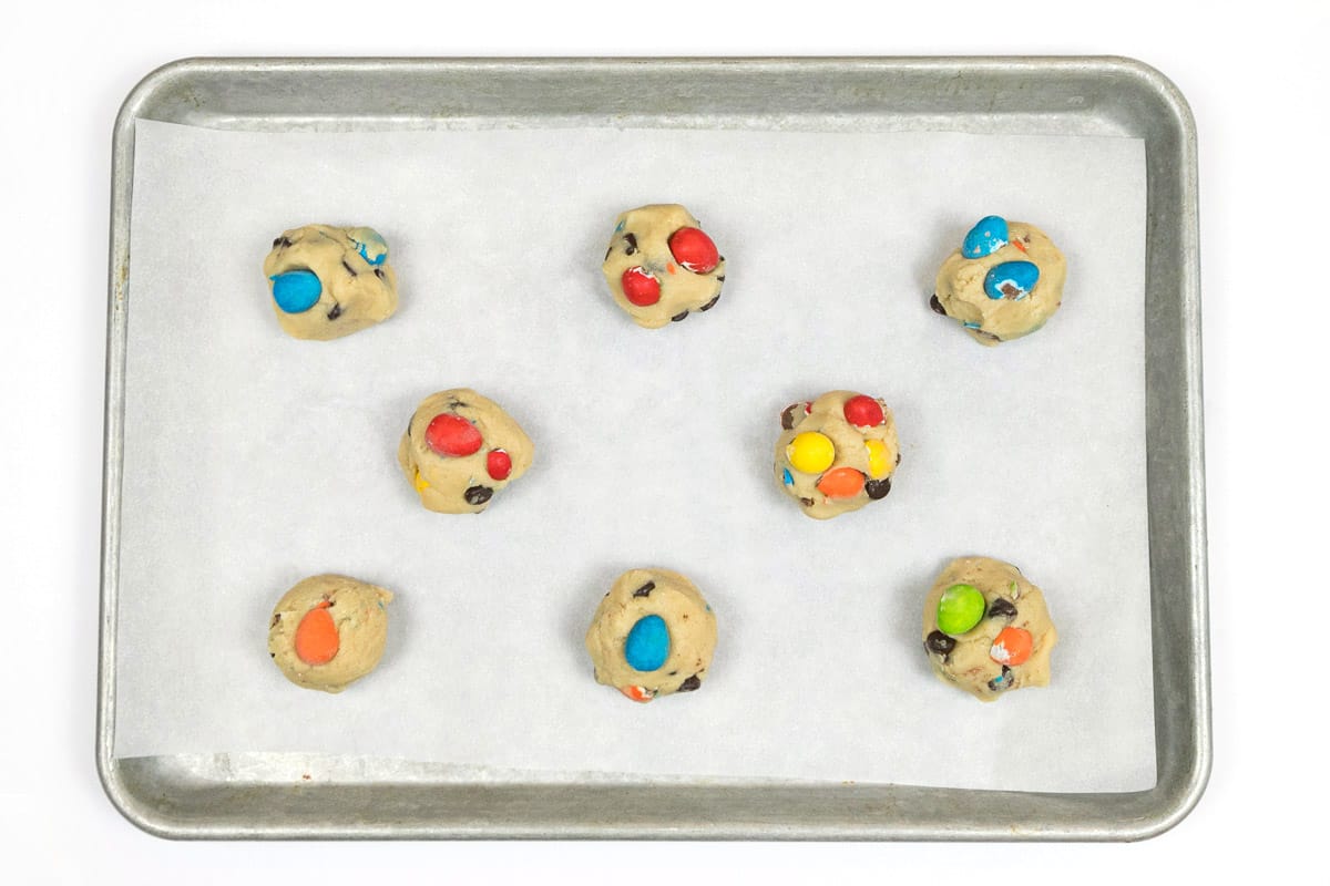 The cookie dough is placed on a cookie sheet with parchment paper.