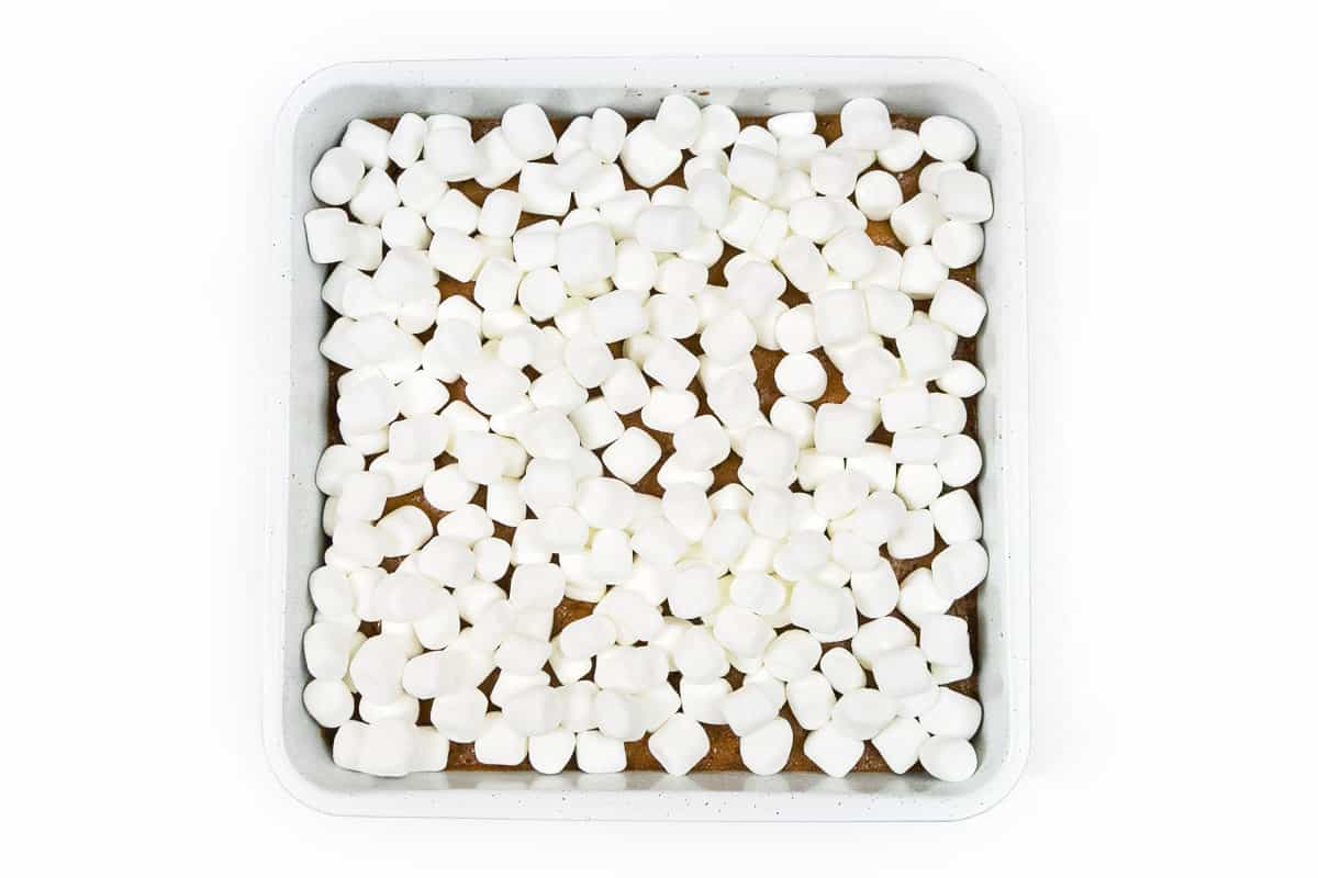 Mini marshmallows are spread on top of the baked sweet potato casserole.