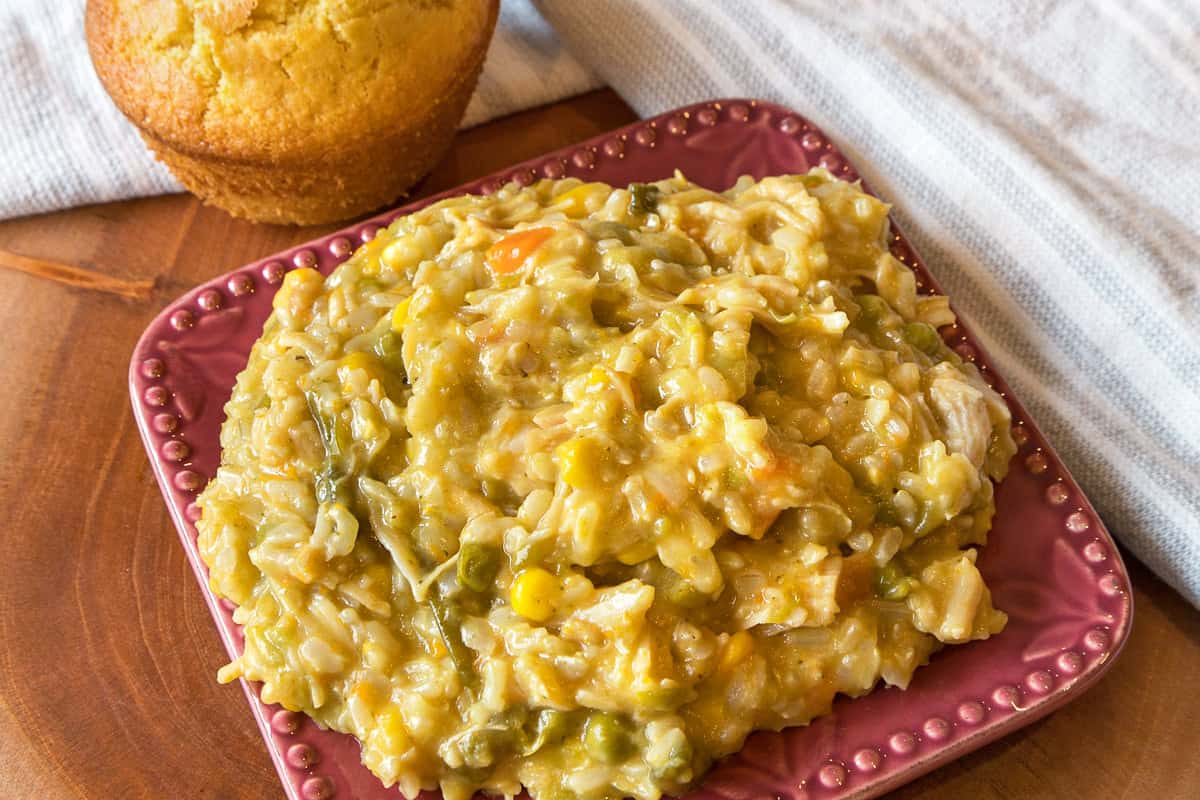 Cheesy chicken and rice casserole on a plate with cornbread.
