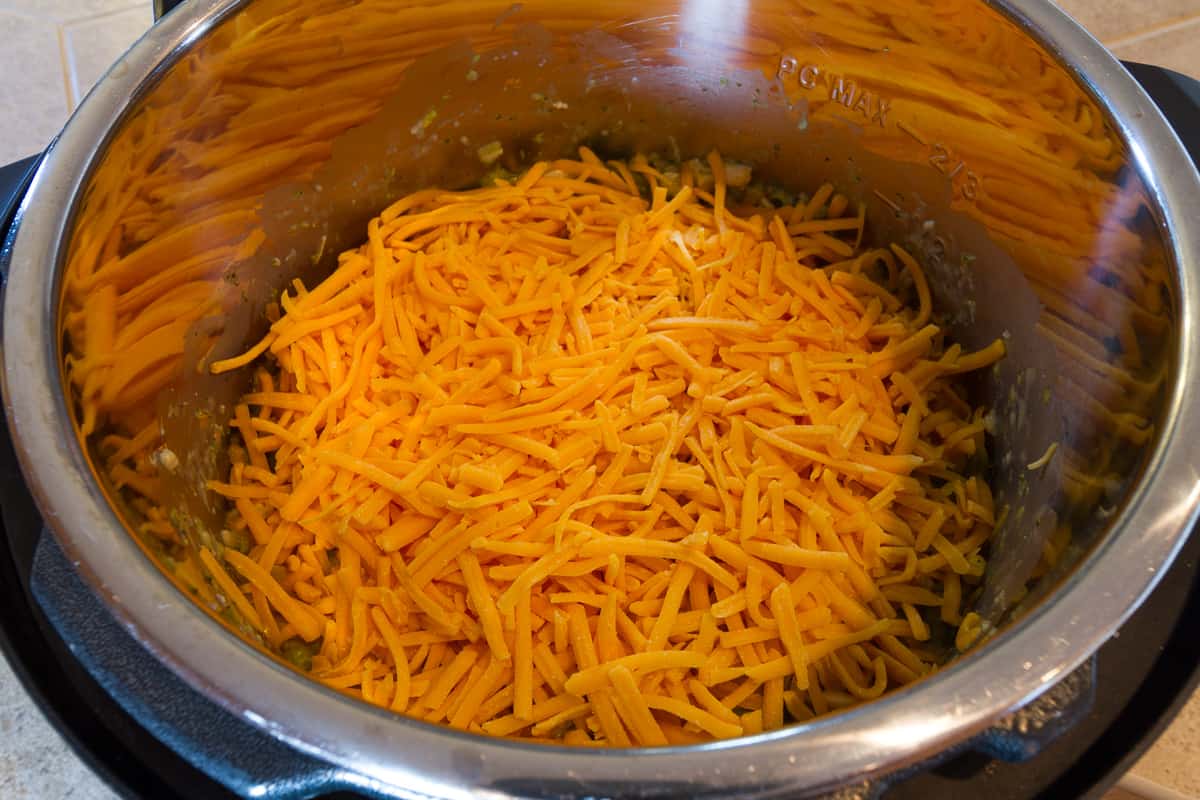 Add the sharp cheese cheddar then put the lid back on without pressurizing it, then let it sit for ten minutes. Then stir ingredients together.