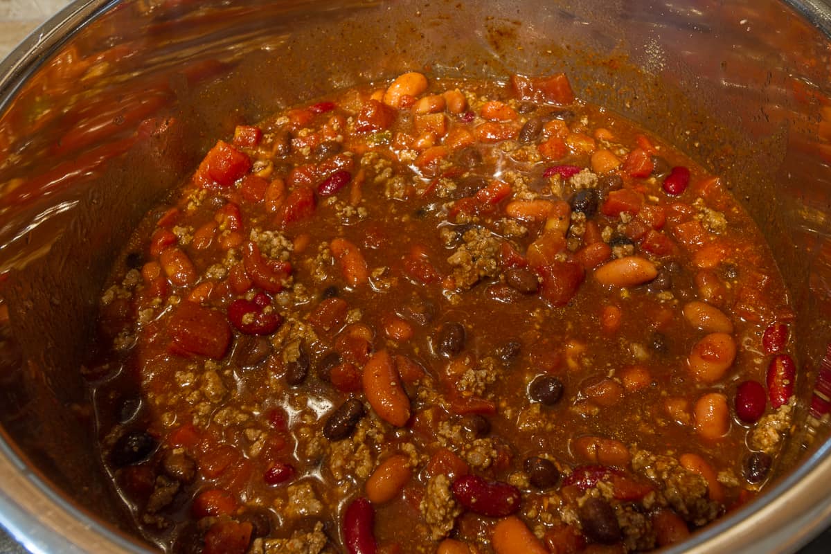 Chili powder, cayenne pepper, garlic powder, brown sugar, and water are added to the chili mixture.