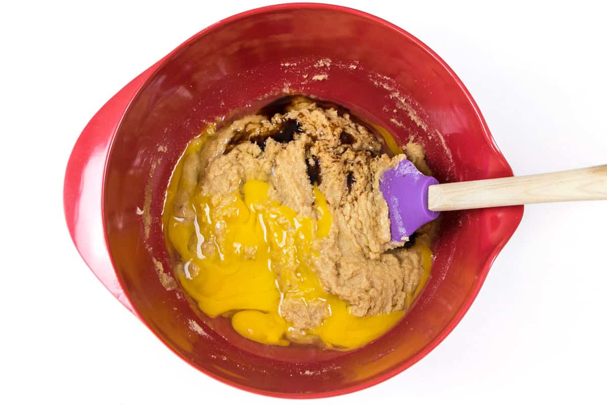 The eggs and vanilla extract are added to the softened butter, sugar, and light brown sugar.