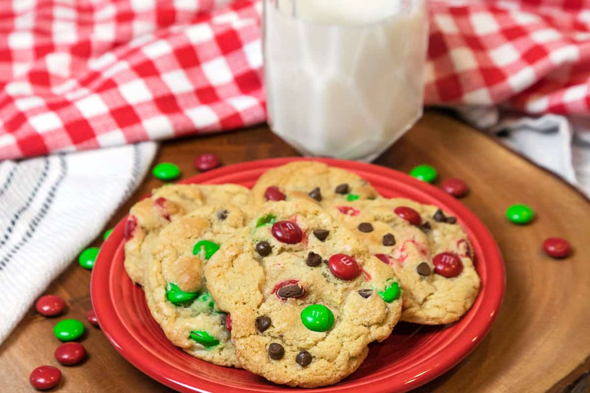 Christmas cookies with M&Ms and a glass of milk.
