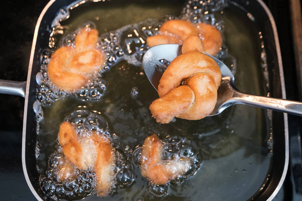 The donuts are deep-fried in the oil.