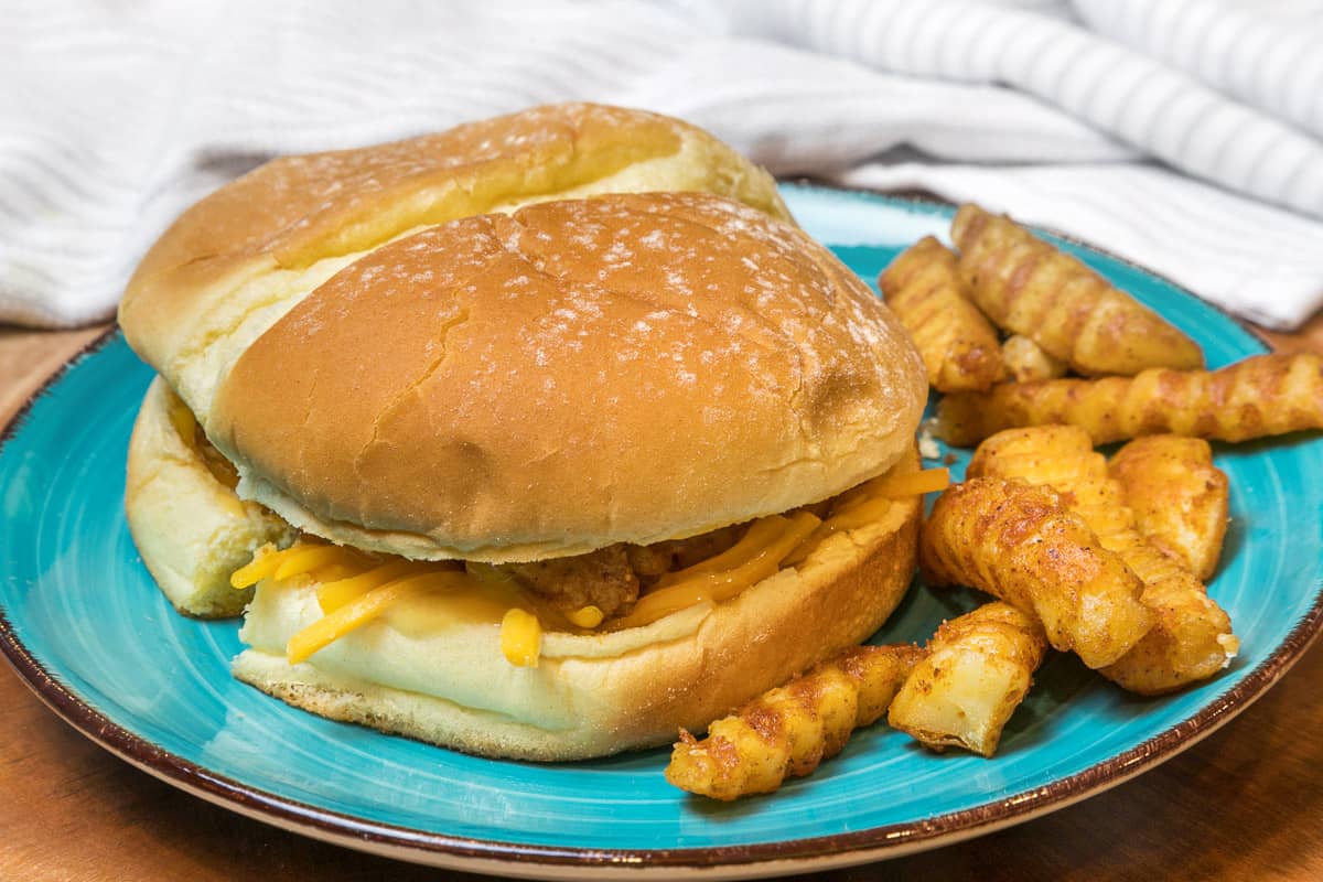 A copycat Chick-fil-A sandwich on a plate with French fries.