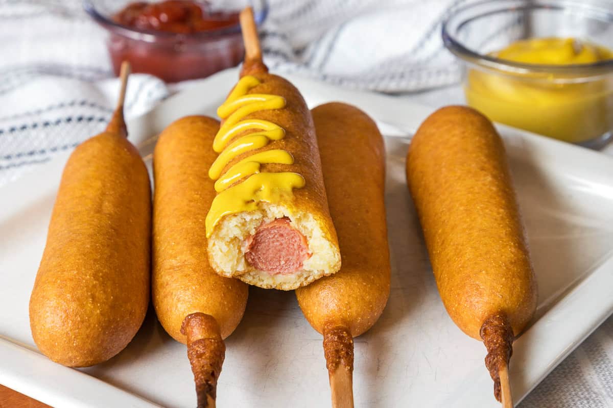 Finished corn dogs on a plate.