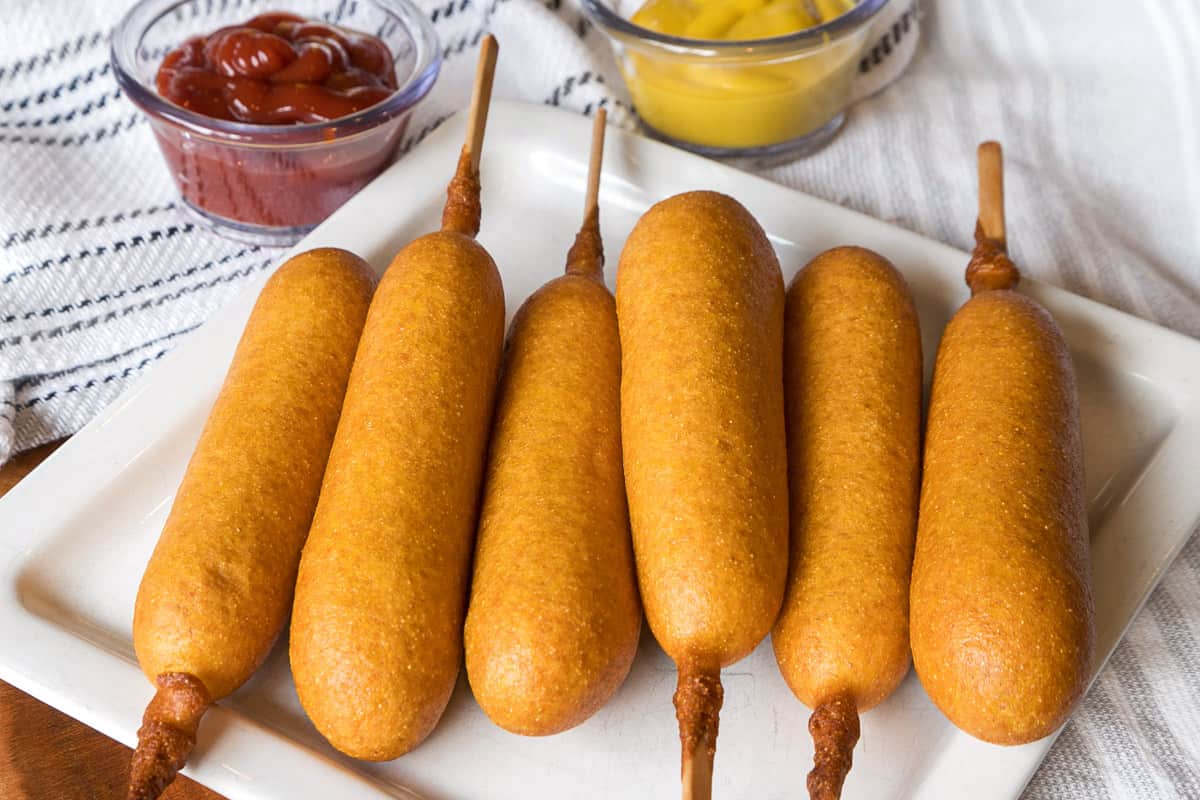 Cooked corn dogs on a plate.