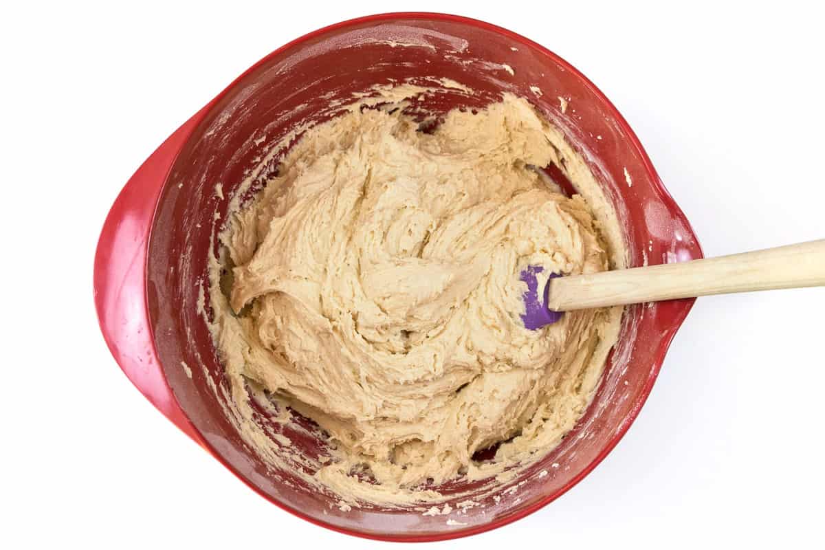 The flour mixture, butter, cream cheese, and sugar mixture are blended in the bowl.