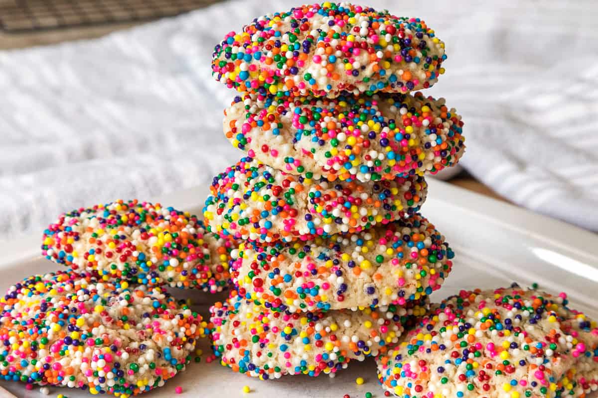 A stack of cream cheese sprinkle cookies on a plate.