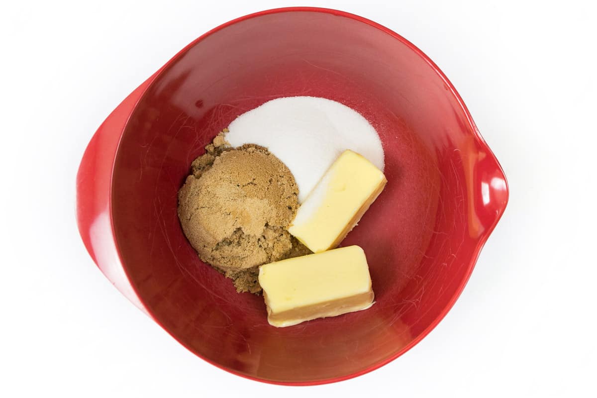 Softened butter, granulated sugar, and dark brown sugar are added to a bowl.
